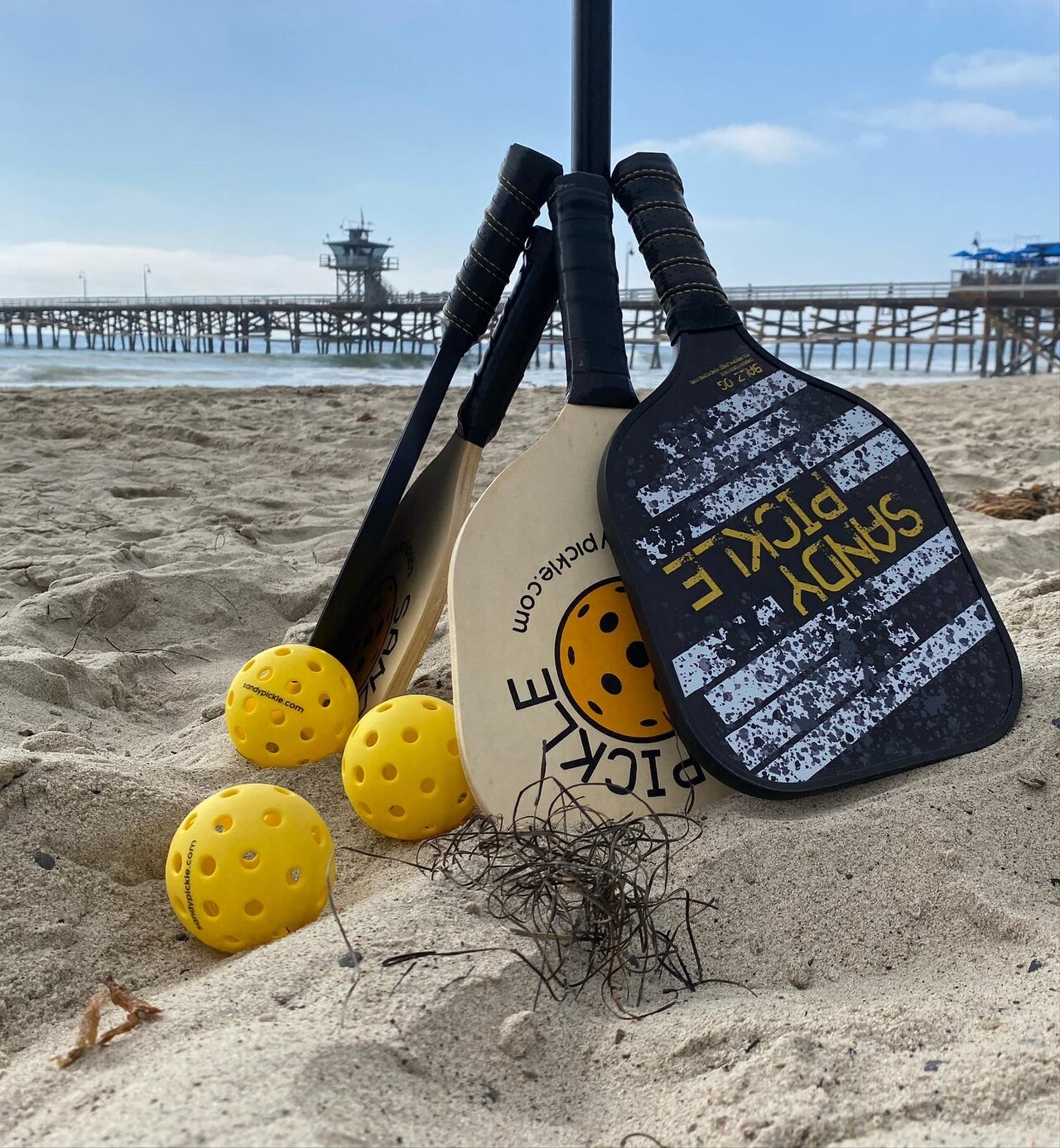 Sandy Pickle is played using a standard pickleball paddle and outdoor ball. Reference photograph; not represented as the Miami story venue or its named subjects..